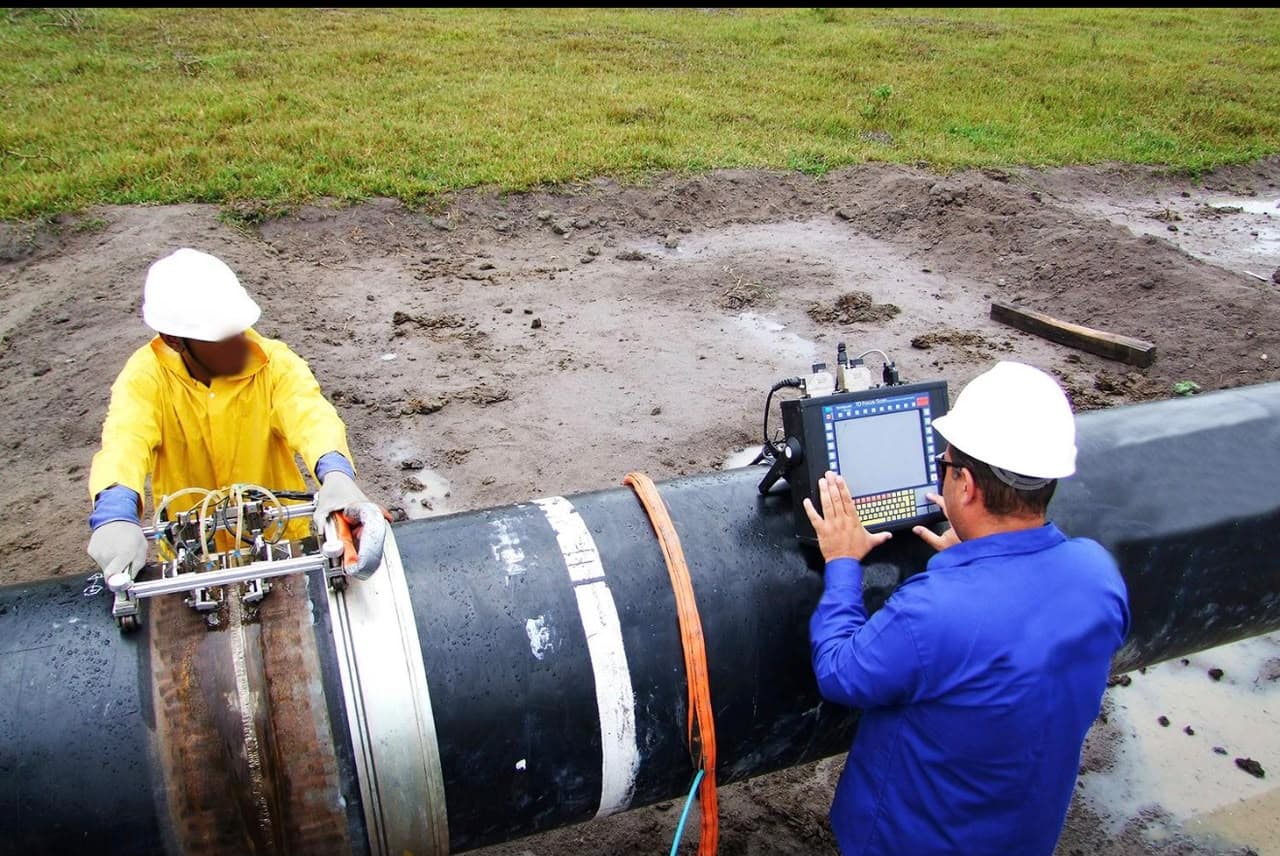 Technicians inspecting a pipeline weld